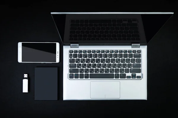Bir flash sürücü, harici sabit disk, smartphone ve siyah masa üstünde açık bir laptop. Mobil veri depolama kavramı. Düz yatıyordu