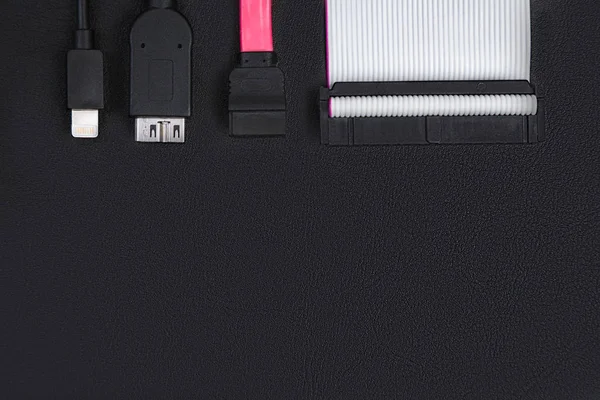 SATA kablosu, usb ve IDE kabloları üstünde siyah okul sırası. Üstten görünüm. Veri depolama kavramı