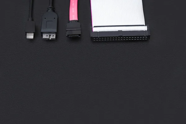 SATA kablosu, usb ve IDE kabloları üstünde siyah okul sırası. Veri depolama kavramı