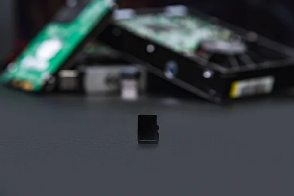 Mikrop SD oyun kağıdı eski depolama yöntemleri için sabit diskler arka planda bir yedek olarak. Bilgisayar ve hdd kavramı.