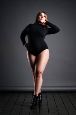 Artı boyutu seksi model siyah elbise, gri studio arka plan, kilolu kadın bedeni, tam uzunlukta portre şişman kadın