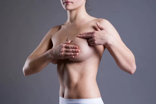 女性のがん 女性の身体は 灰色の背景に撮影スタジオでの痛みのための彼女の胸を調べる — ストック写真