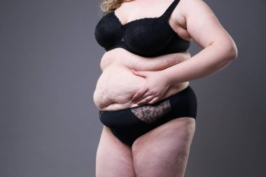 Şişman karın ile obez kadın kilolu kadın mide gri studio arka plan üzerinde