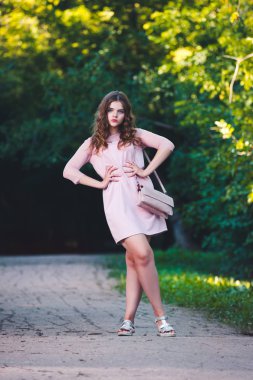 Güzel, Genç bir beyaz kadın pembe elbise, uzun saç ve rahat makyaj, Doğa arka plan tam uzunlukta portresi