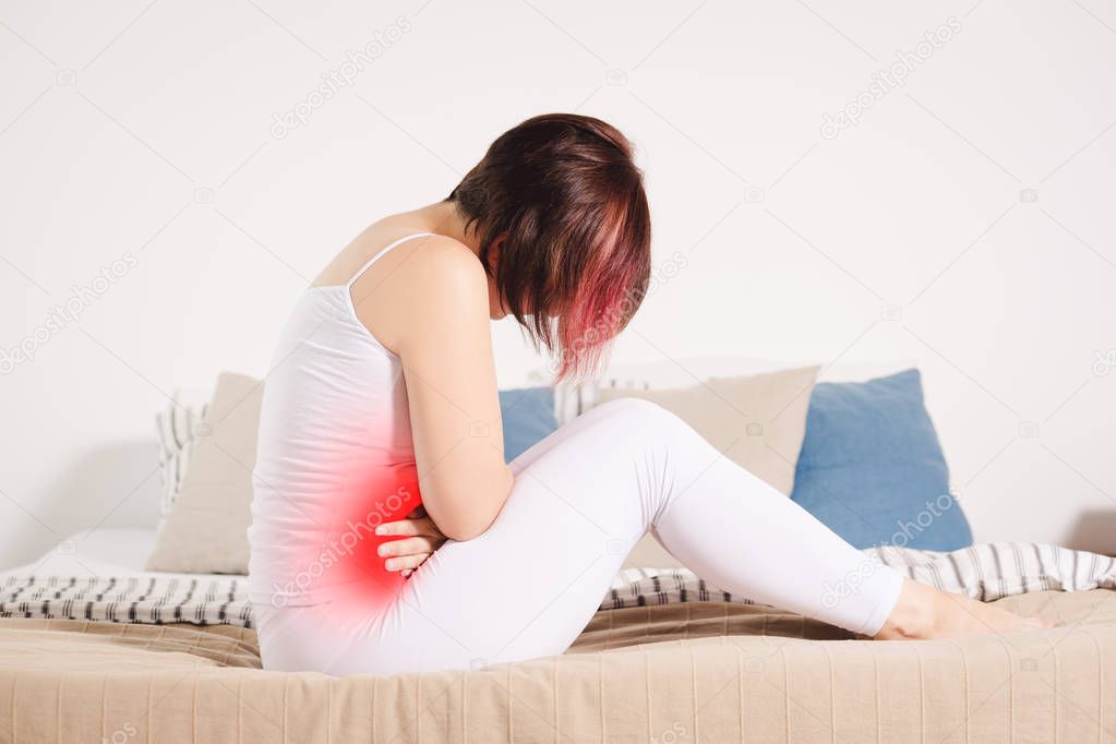 Stomach ache, woman with abdominal pain suffering at home, painful area highlighted in red