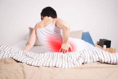 Back pain, kidney inflammation, woman suffering from backache at home, painful area highlighted in red clipart