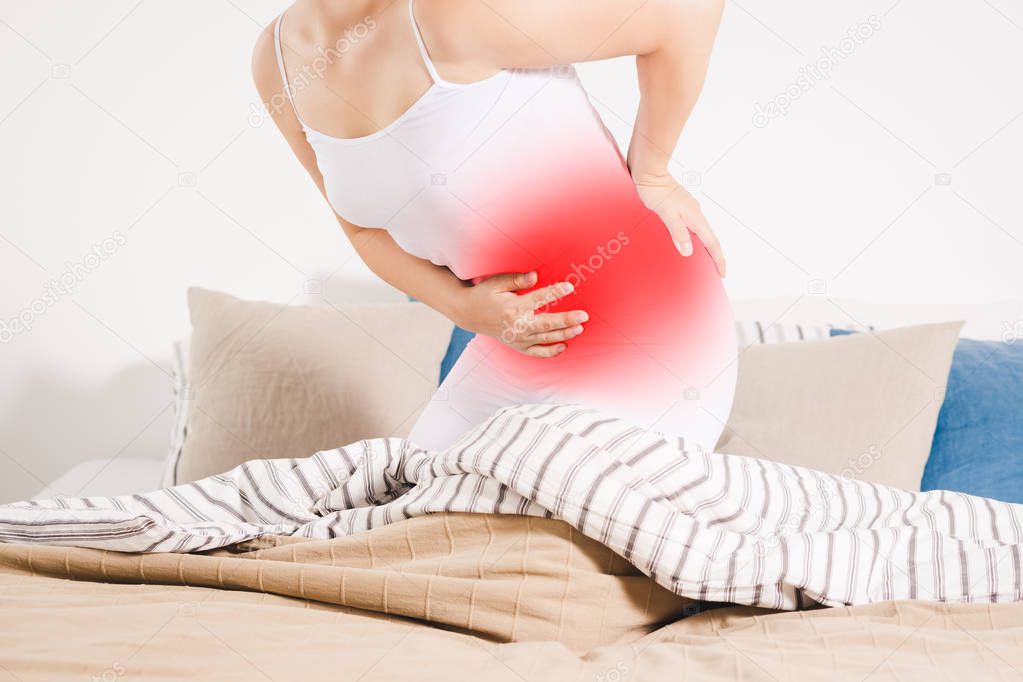 Stomach ache, woman with abdominal pain suffering at home, painful area highlighted in red