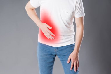 Apandisit, adam gri arka plan, kırmızı renkte acı alan üzerinde karın ağrısı olan acı krizinden