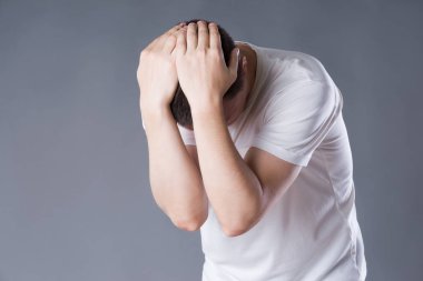 Baş ağrısı ve Migren, baş ağrısı gri arka plan, stüdyo çekim üzerinde olan adam