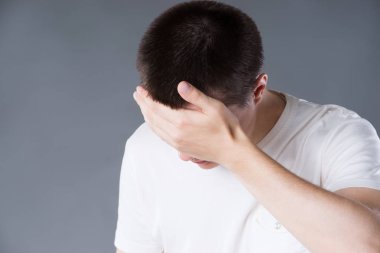 Baş ağrısı ve Migren, baş ağrısı gri arka plan, stüdyo çekim üzerinde olan adam