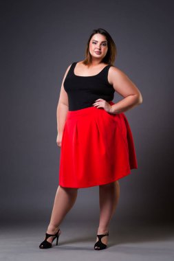 Artı boyutu moda model kırmızı etek, gri studio arka planda, şişman kadın kilolu kadın bedeni, tam uzunlukta portre