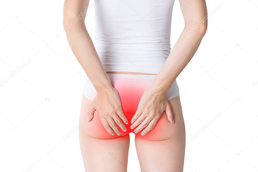 Woman suffering from hemorrhoids, anal pain on gray background, painful area highlighted in red