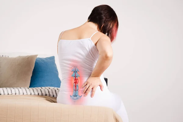 腰痛を家庭より低い背部に傷害 強調表示されたスケルトンと写真の女性の痛み ストック画像