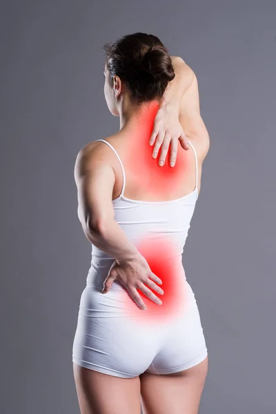妇女背痛在灰色背景 工作室拍摄 痛苦的区域突出在红色 — 图库照片