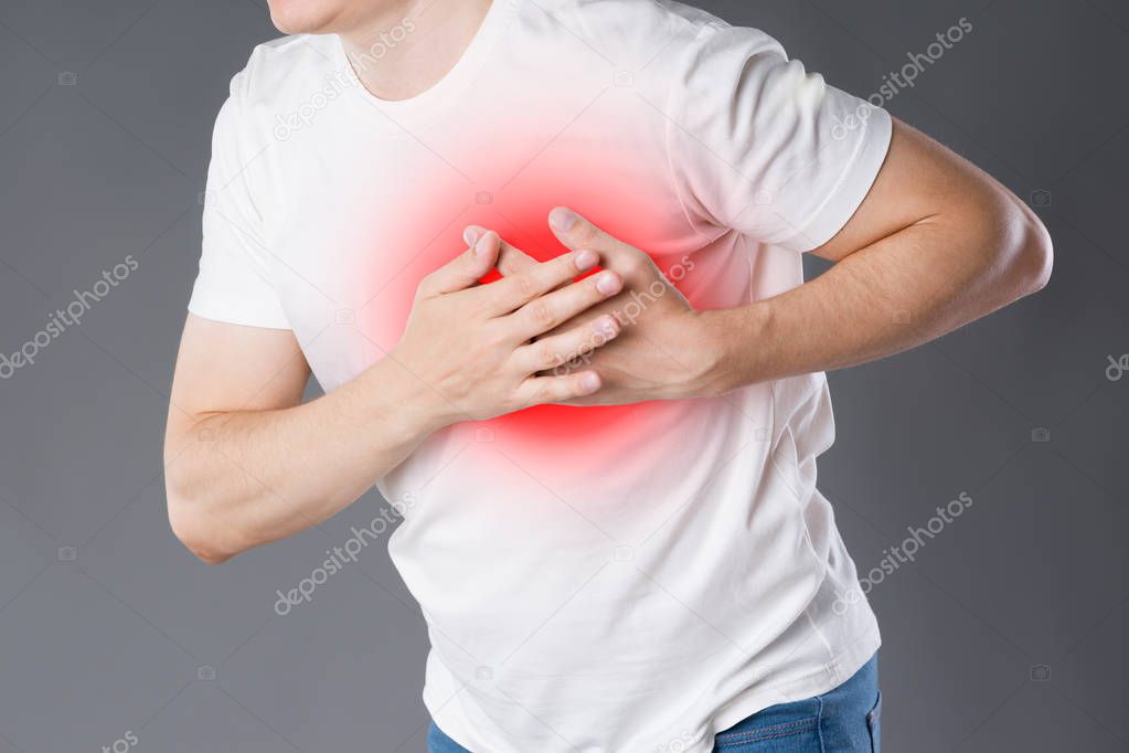 Heart attack, man with chest pain on gray background with red dot