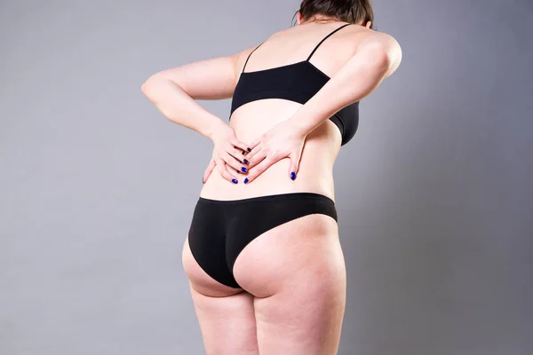 Back pain, kidney inflammation, ache in woman\'s body on gray background