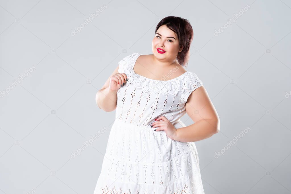 Plus size fashion model in casual clothes, fat woman on gray studio background, overweight female body