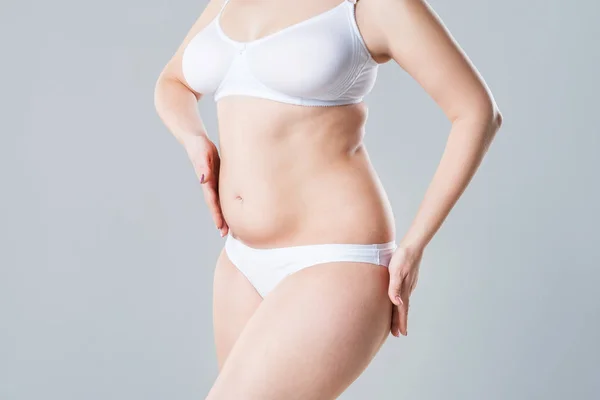 Donna con pancia grassa flaccida, corpo femminile sovrappeso su sfondo grigio — Foto Stock