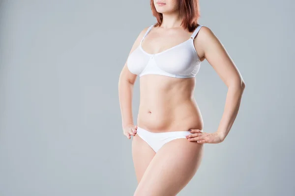 Mulher com barriga gorda e flácida, corpo feminino com excesso de peso em fundo cinza — Fotografia de Stock