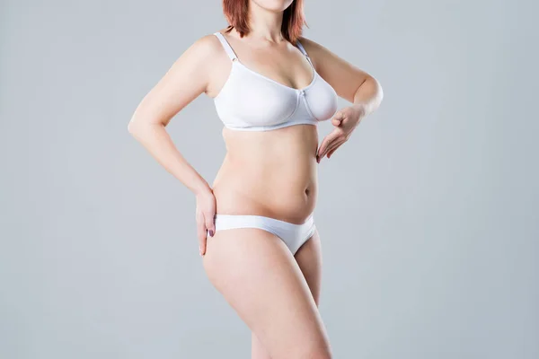 Kobieta z tłustym zwiotczałym brzuchem, nadwagą kobiece ciało na szarym tle — Zdjęcie stockowe