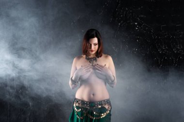 Seksi kadın karanlık dumanlı arka planda etnik elbise oryantal dans gerçekleştirir, soyut sanat fotoğrafçılığı