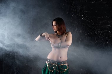 Seksi kadın karanlık dumanlı arka planda etnik elbise oryantal dans gerçekleştirir, soyut sanat fotoğrafçılığı