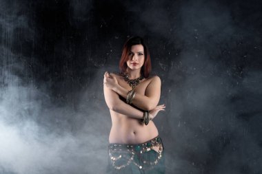 Seksi kadın karanlık dumanlı arka planda etnik elbise oryantal dans gerçekleştirir, soyut sanat fotoğrafçılığı
