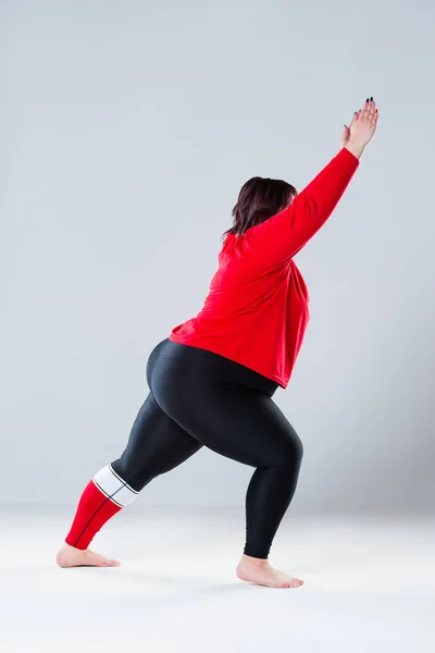 Plus size model in sportswear, fat woman doing workout on gray background, healthy lifestyle concept, body positive — Stock Photo, Image