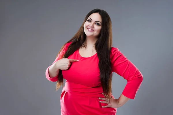 Happy plus size model in red dress, fat woman with long hair on gray background, body positive concept — Stock Photo, Image