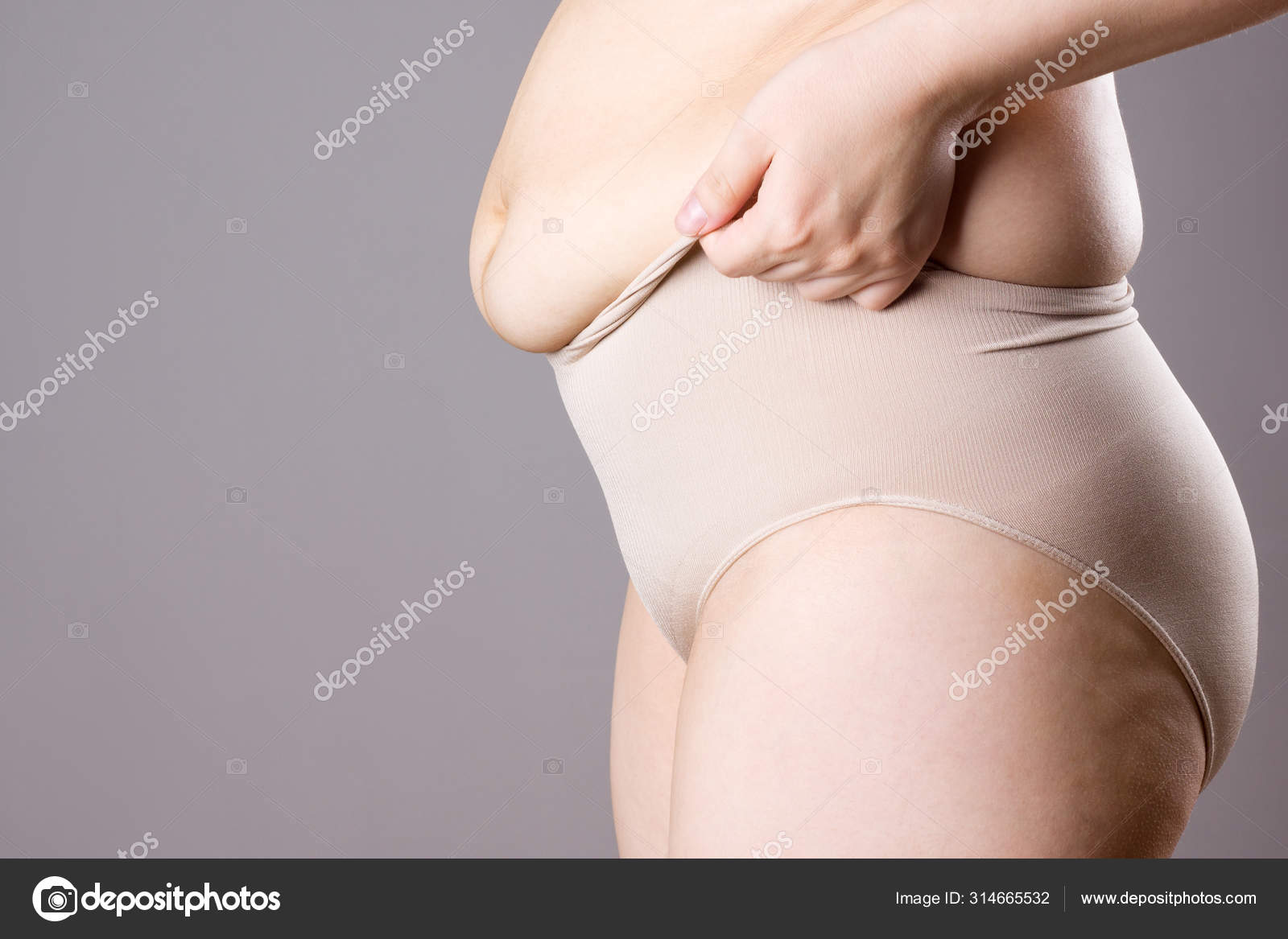 Fat woman in corrective panties, flabby belly after pregnancy, overweight  female body on gray background Stock Photo by ©starast 314665532