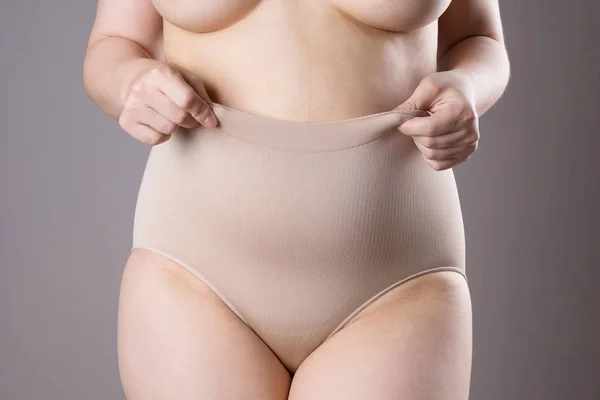 Mulher em calcinha corretiva, corpo feminino com excesso de peso em shapewear no fundo cinza — Fotografia de Stock