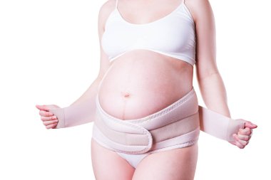 Ortopedik destek kemeri olan hamile bir kadın, beyaz arka planda izole edilmiş.