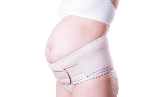 Беременная женщина с ортопедическим поясом поддержки, изолированная на белом фоне — стоковое фото