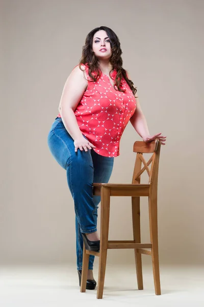 Happy beautiful young caucasian plus size model in blue jeans