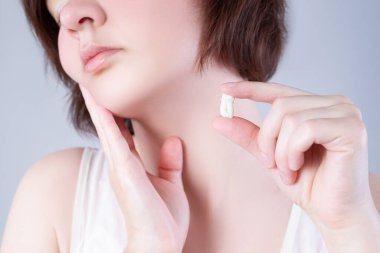 Yirmilik diş çektirme, arka planda diş ağrısı çeken bir kadın, dişçilik konsepti.