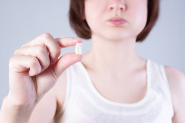 Yirmilik diş çektirme, arka planda diş ağrısı çeken bir kadın, dişçilik konsepti.