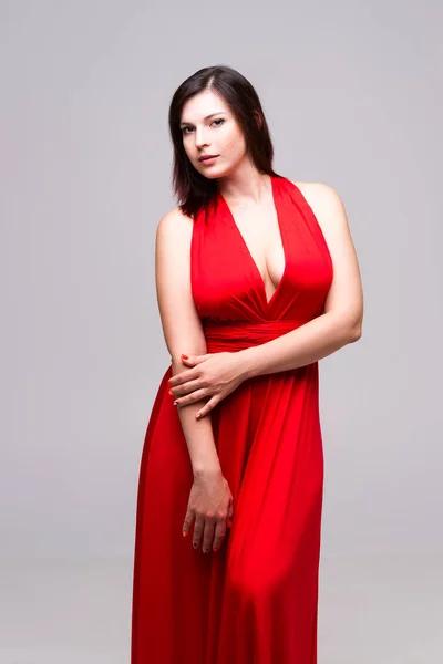 Сексуальная Женщина Красном Платье Глубоким Декольте Студии Сером Фоне — стоковое фото