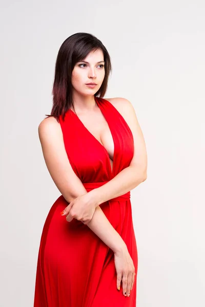 Sexy Žena Červených Šatech Hlubokým Výstřihem Studiu Šedém Pozadí — Stock fotografie