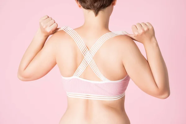 穿着粉色背景的运动胸罩的女人 身体护理的概念 — 图库照片