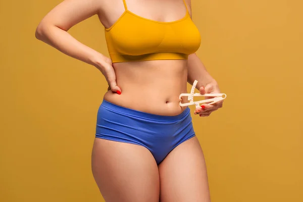 美しいです女性でカラフルな下着測定彼女の体脂肪とともにキャリパーで黄色の背景 ボディケアの概念 — ストック写真