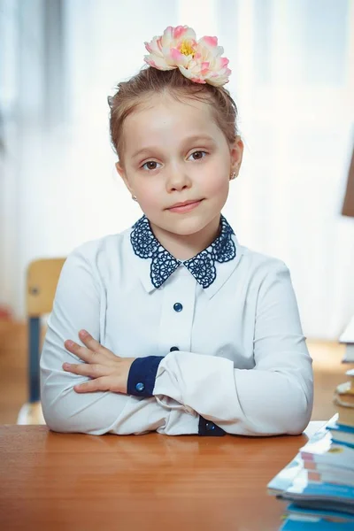 A schoolgirl sits at a desk — Stock Photo, Image