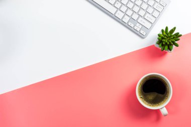 Beyaz ve pembe arka plan, üstten görünüm üzerinde kaktüs pot ve bilgisayar klavye ile kahve fincanı