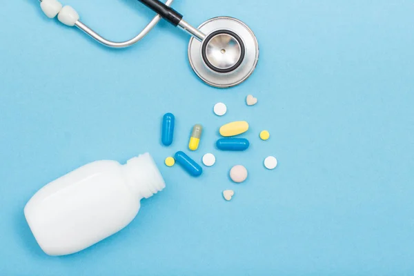 Flacone Bianco Con Diverse Pillole Capsule Fonendoscopio Sfondo Blu Medicinali — Foto Stock