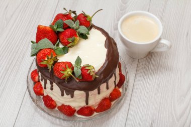 Cam levha ve gri ahşap zemin üzerine kahve taze çilek ile dekore edilmiş ev yapımı çikolatalı kek