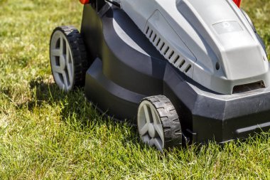 Modern elektrikli çim biçme makinesi üzerinde taze çimen yeşil çim ile kesilmiş
