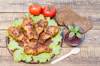 Izgara tavuk budu ve marul yaprakları Ahşap Doğrama tahtası üzerinde domates sos yeşil fesleğen, domates ve ayçiçeği tohumu ile siyah ekmek ile dekore edilmiş cam kase