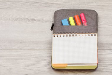 Okul malzemeleri. Açık egzersiz kitap renk ile çanta-kalem duruma kalemler ve marker gri ahşap kurullarında hissettim. Üstten görünüm kopya alanı ile. Geri okul kavramı