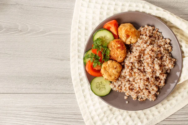 Plaka ile buğday, kızarmış et pirzola, taze salatalık ve domates Mutfak havlu üzerinde parçalar. Kopya alanı ile üstten görünüm