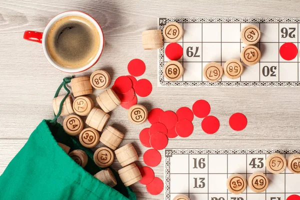 Masa oyunu lotto. Ahşap Loto varil ile yeşil çanta, oyun kartları, kırmızı fişleri ve kahve. Üstten görünüm