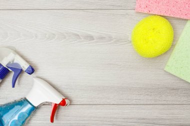 Deterjan, renk mikrofiber bezler ve kopya alanı merkezi gri ahşap zemin üzerine temizlik için sentetik sünger şişe. Araçları ve ekipmanları temizlik seti